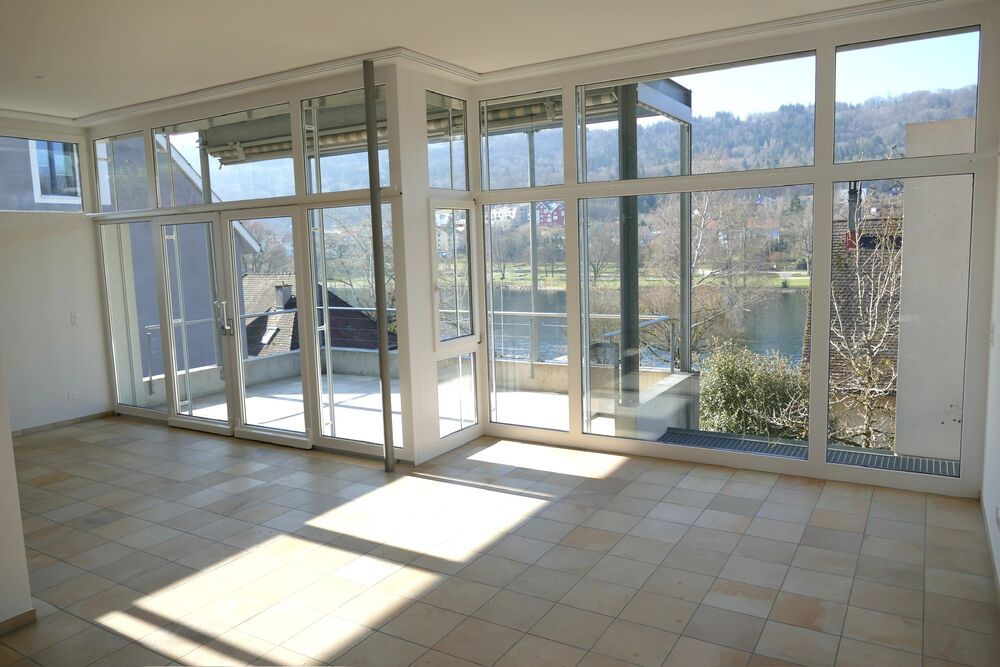 Heller Wintergarten mit Panoramafenstern und Blick ins Grüne