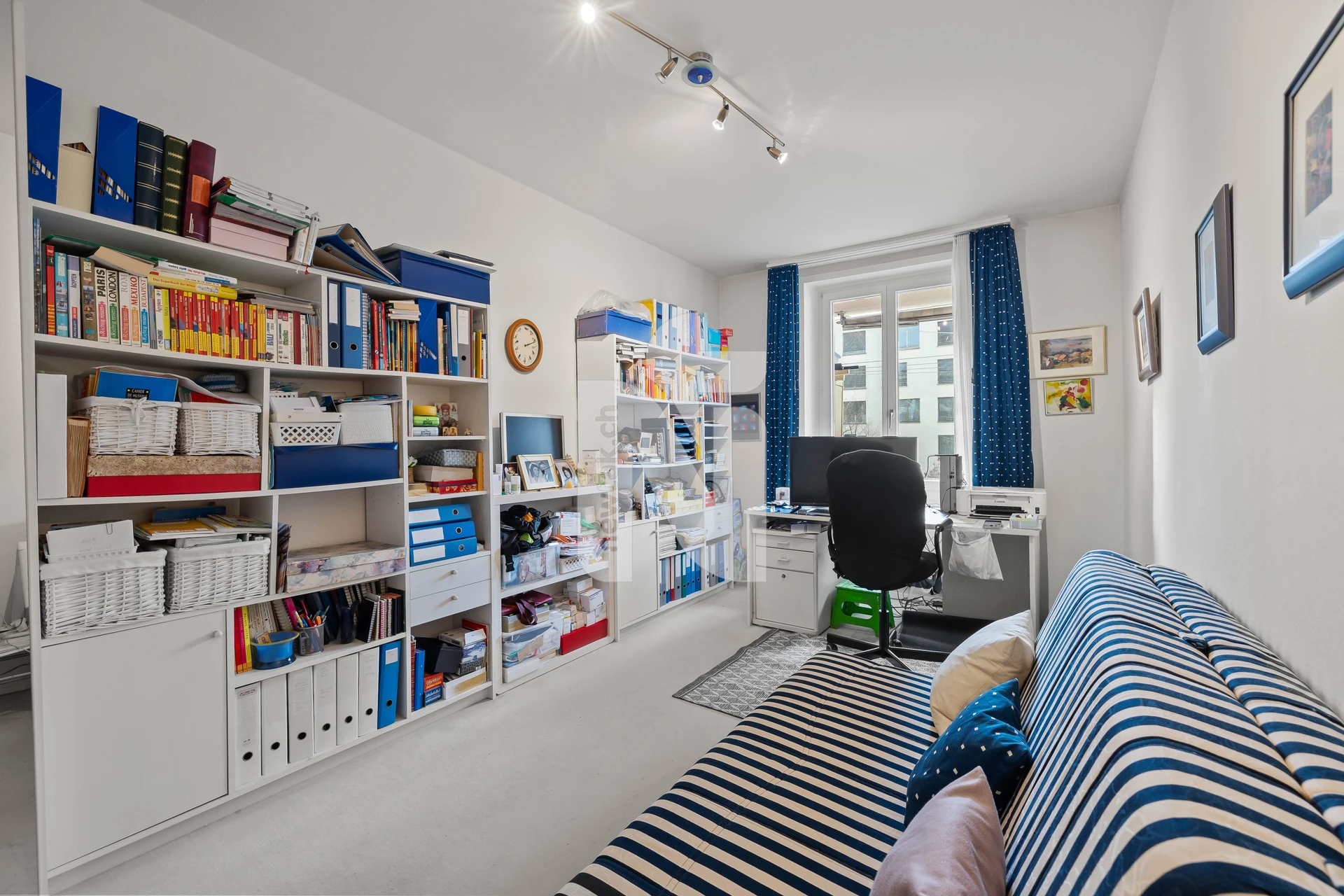 Arbeitszimmer mit Regalen und Fenster