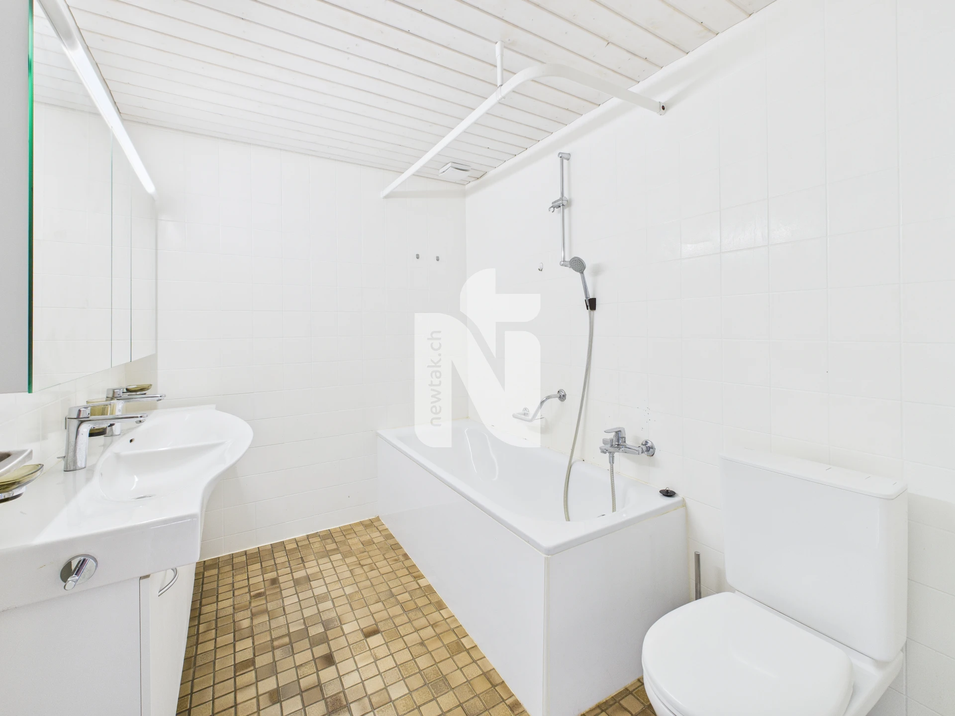Kleines weißes Badezimmer mit Badewanne und WC