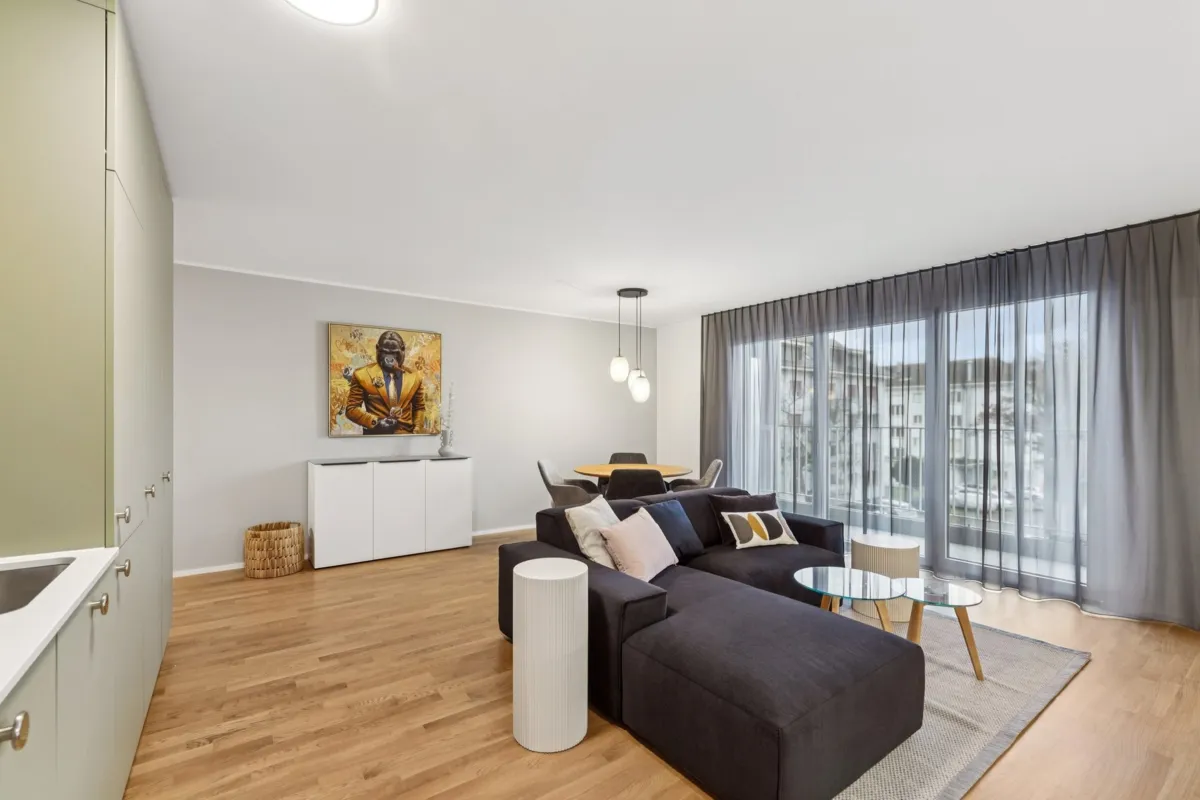 Helles Wohnzimmer mit Essbereich und Balkonblick