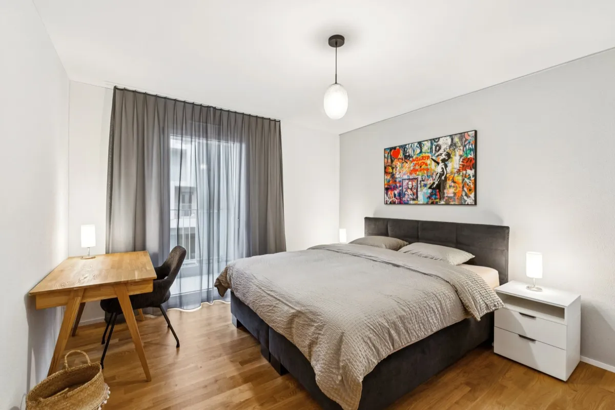 Helles Schlafzimmer mit Bett und Schreibtisch
