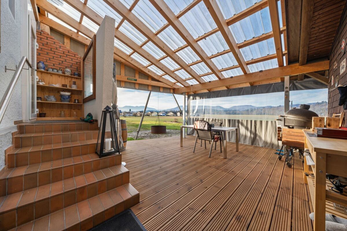 Überdachte Terrasse mit Holzdecke und Gartenblick