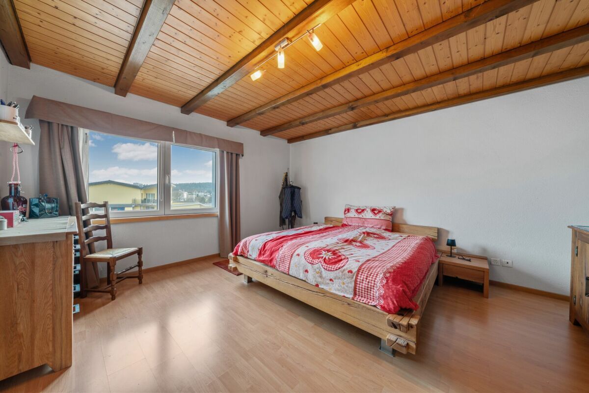 Helles Schlafzimmer mit Holzdecke und Blick nach draußen
