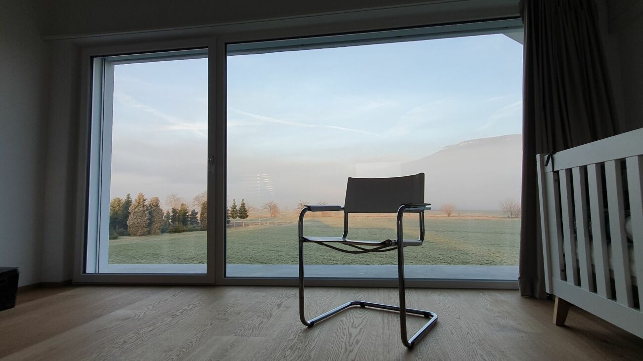 Helles Zimmer mit Panoramafenster und Stuhl
