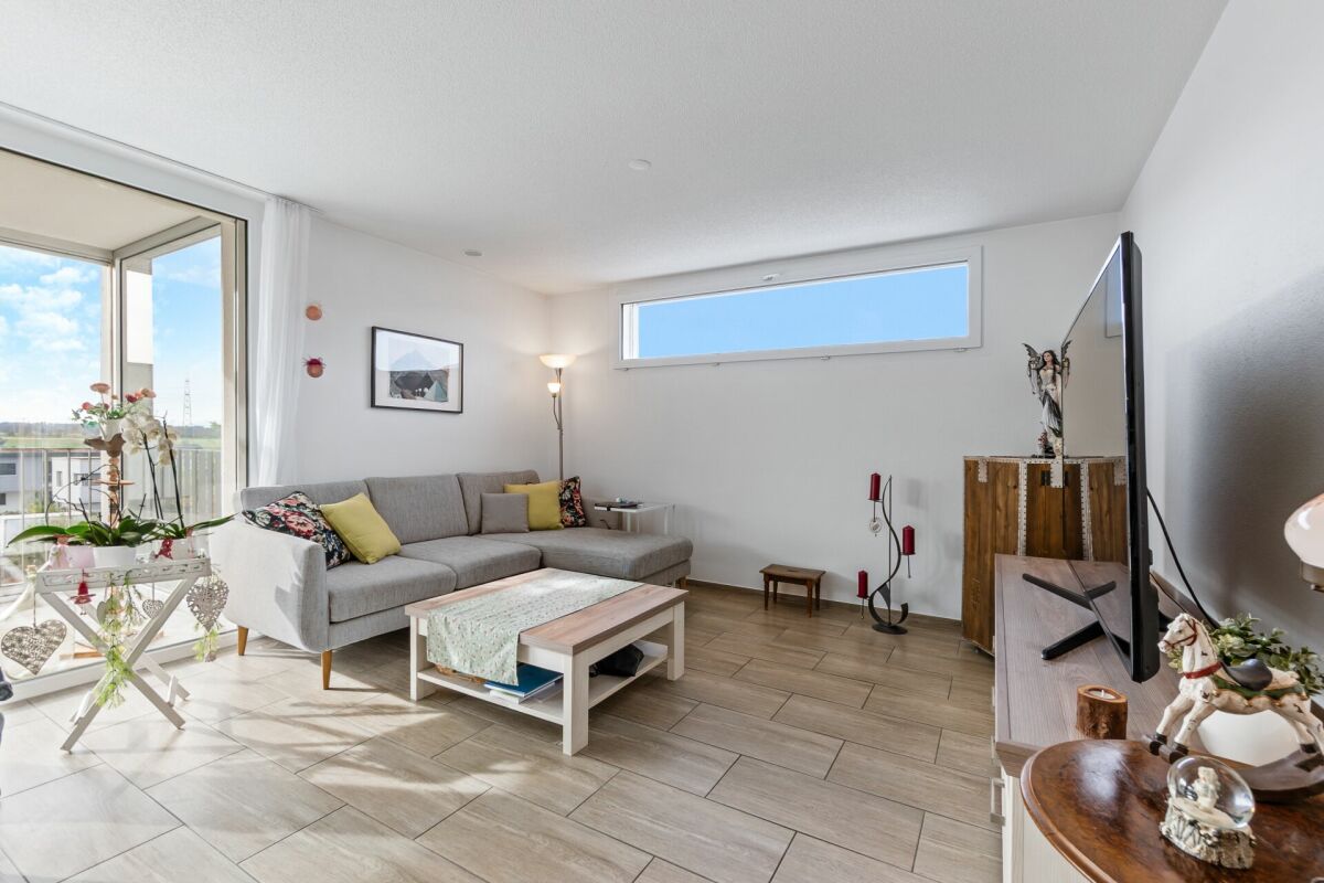Heller Wohnbereich mit Balkon und L-förmigem Sofa