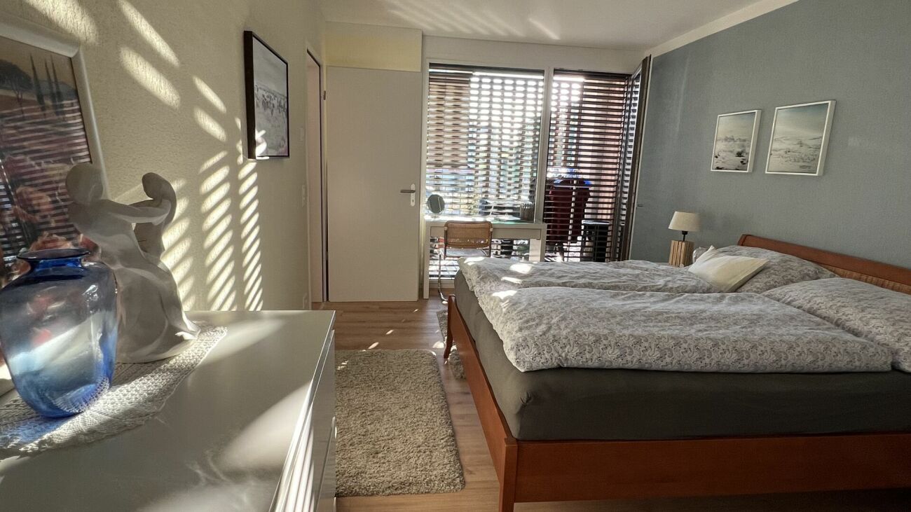 Helles Schlafzimmer mit Doppelbett und Sonnenlicht