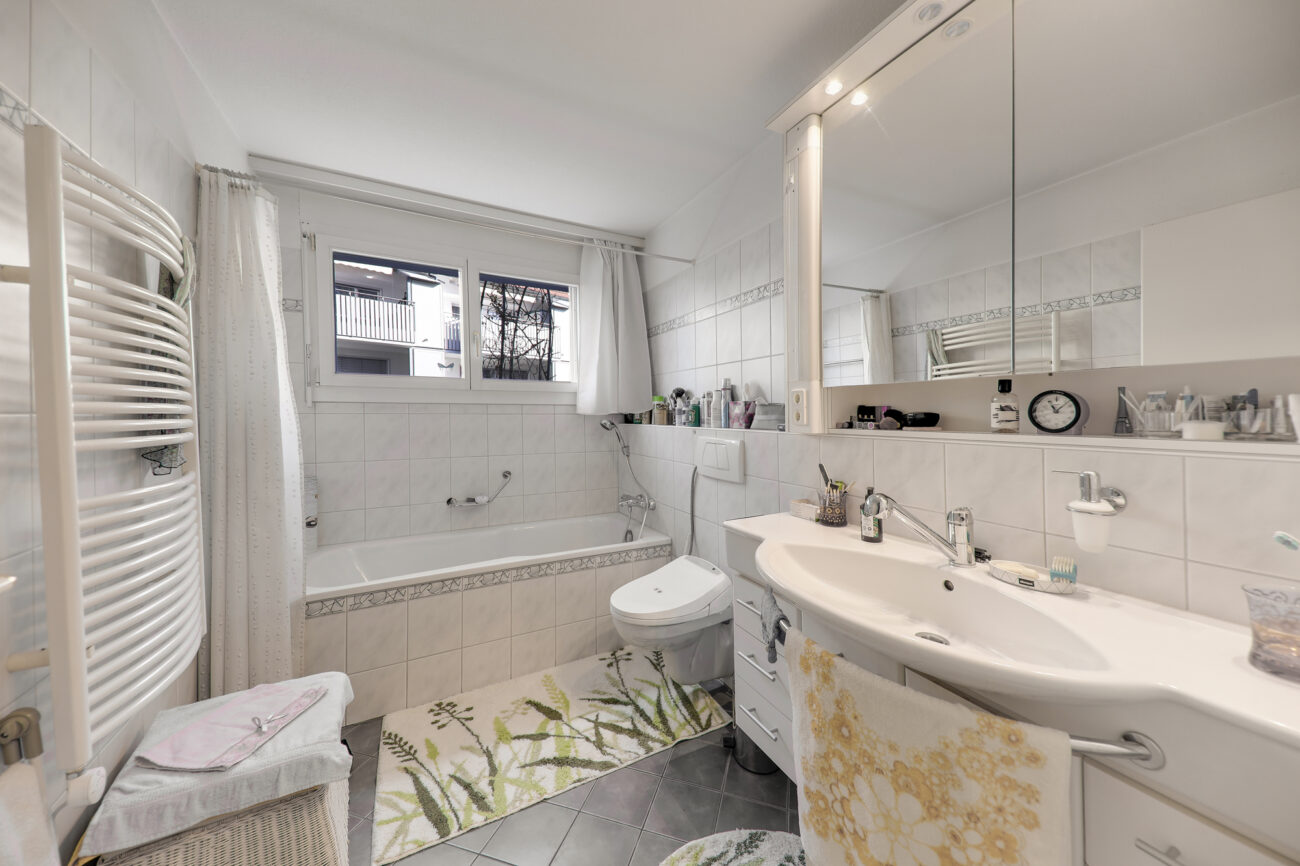 Helles Badezimmer mit Badewanne und Waschtisch