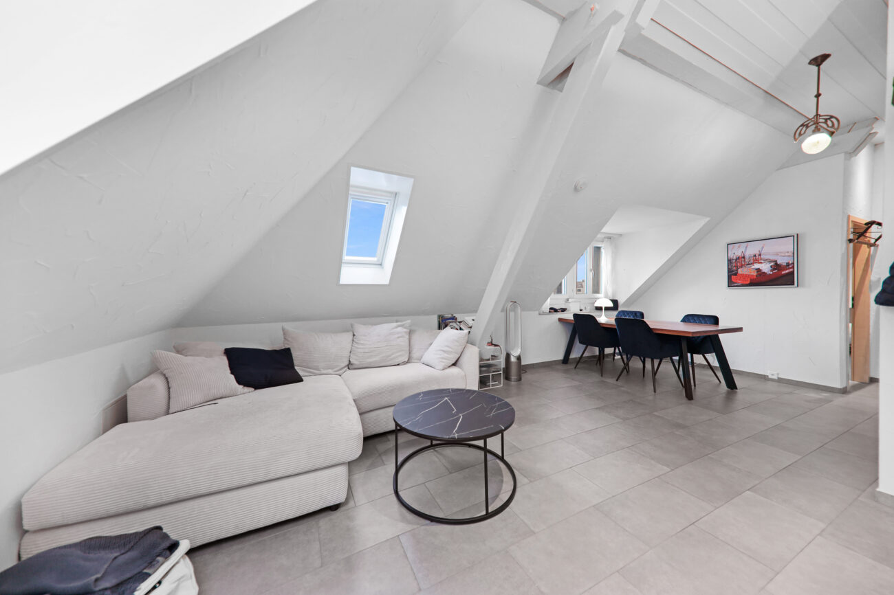 Ausgebauter Dachgeschoss-Wohnraum mit Sofaecke und Essbereich
