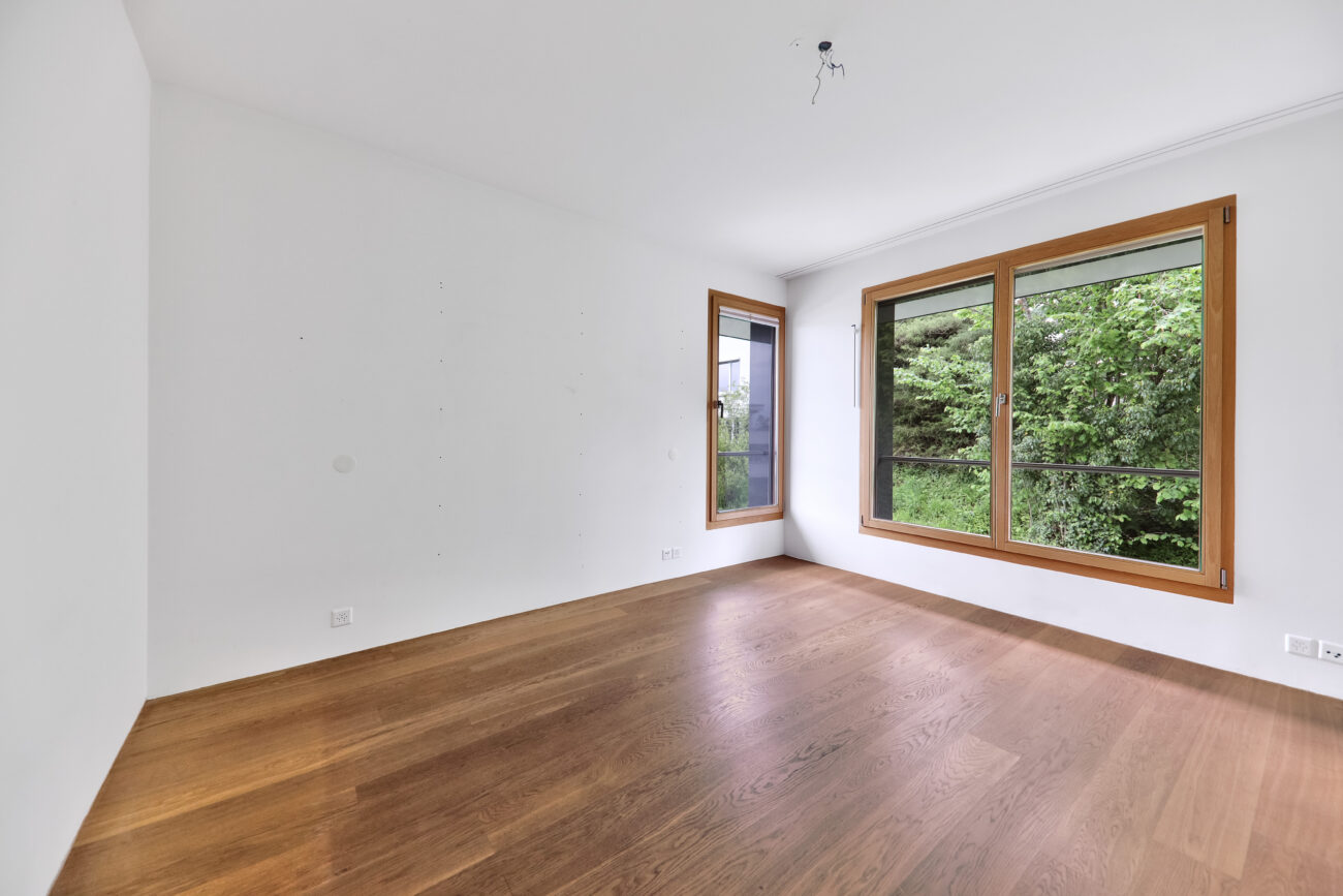 Leerer, heller Raum mit Holzfenstern