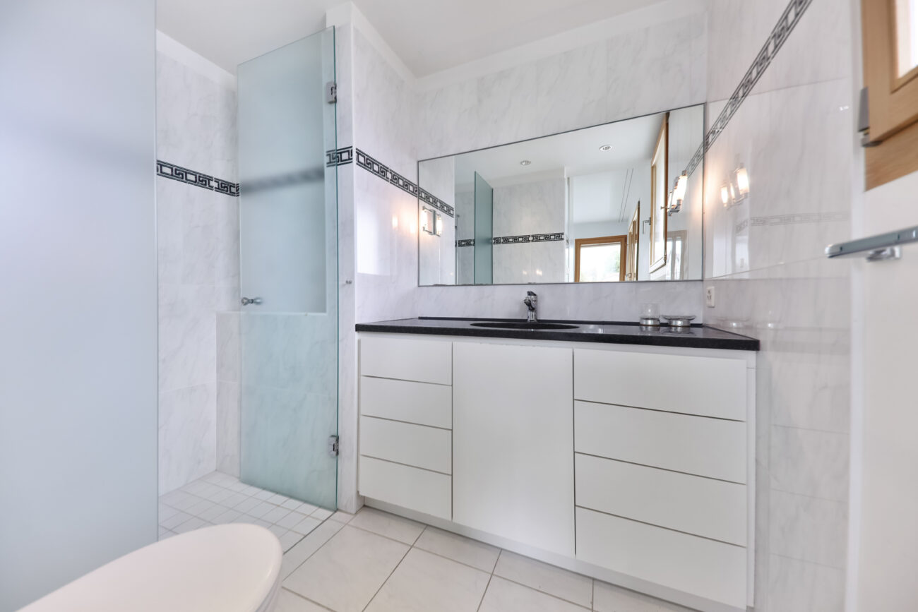 Helles Badezimmer mit Waschtisch und Dusche