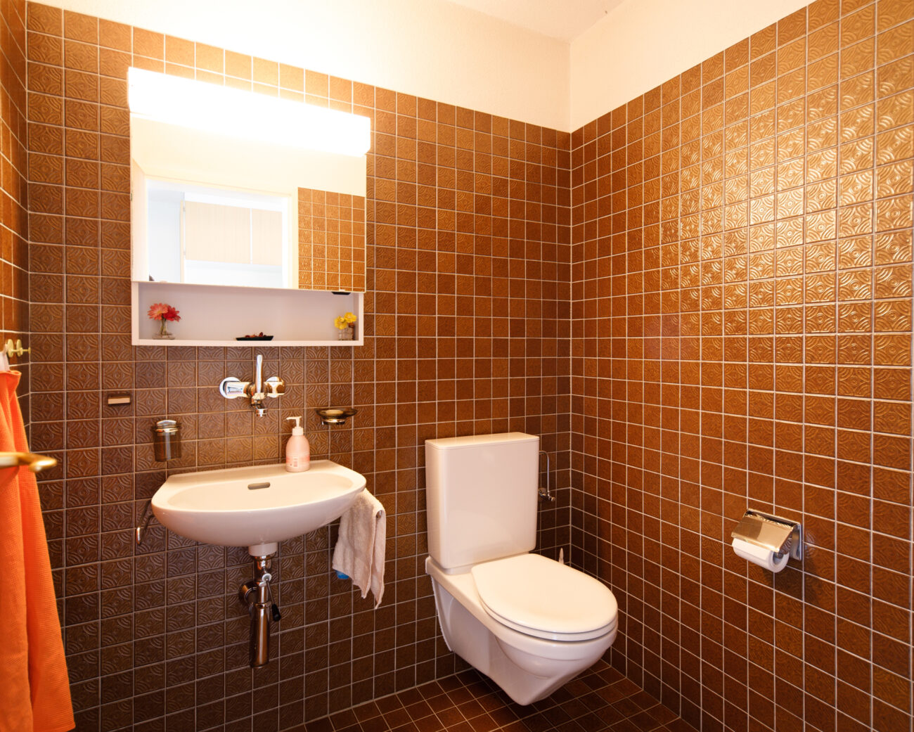 Retro-Gäste-WC mit braunen Wandfliesen