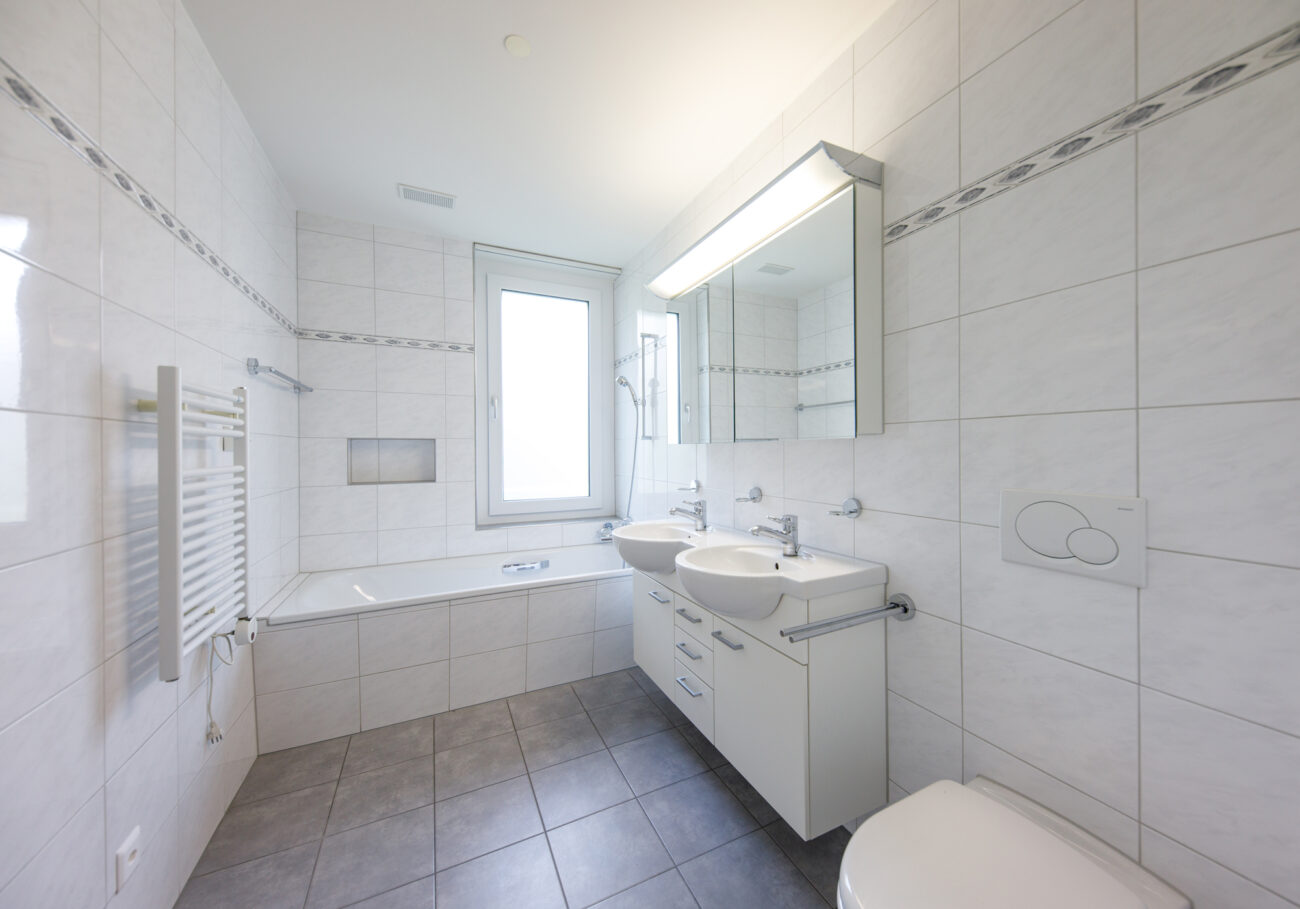 Helles Badezimmer mit Badewanne und Doppelwaschtisch