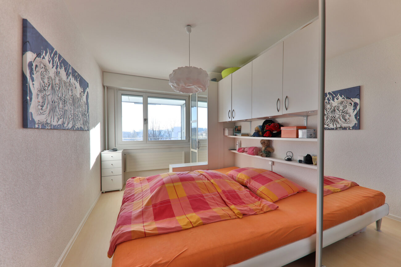 Schlafzimmer mit Einbauschrank und Fensterfront