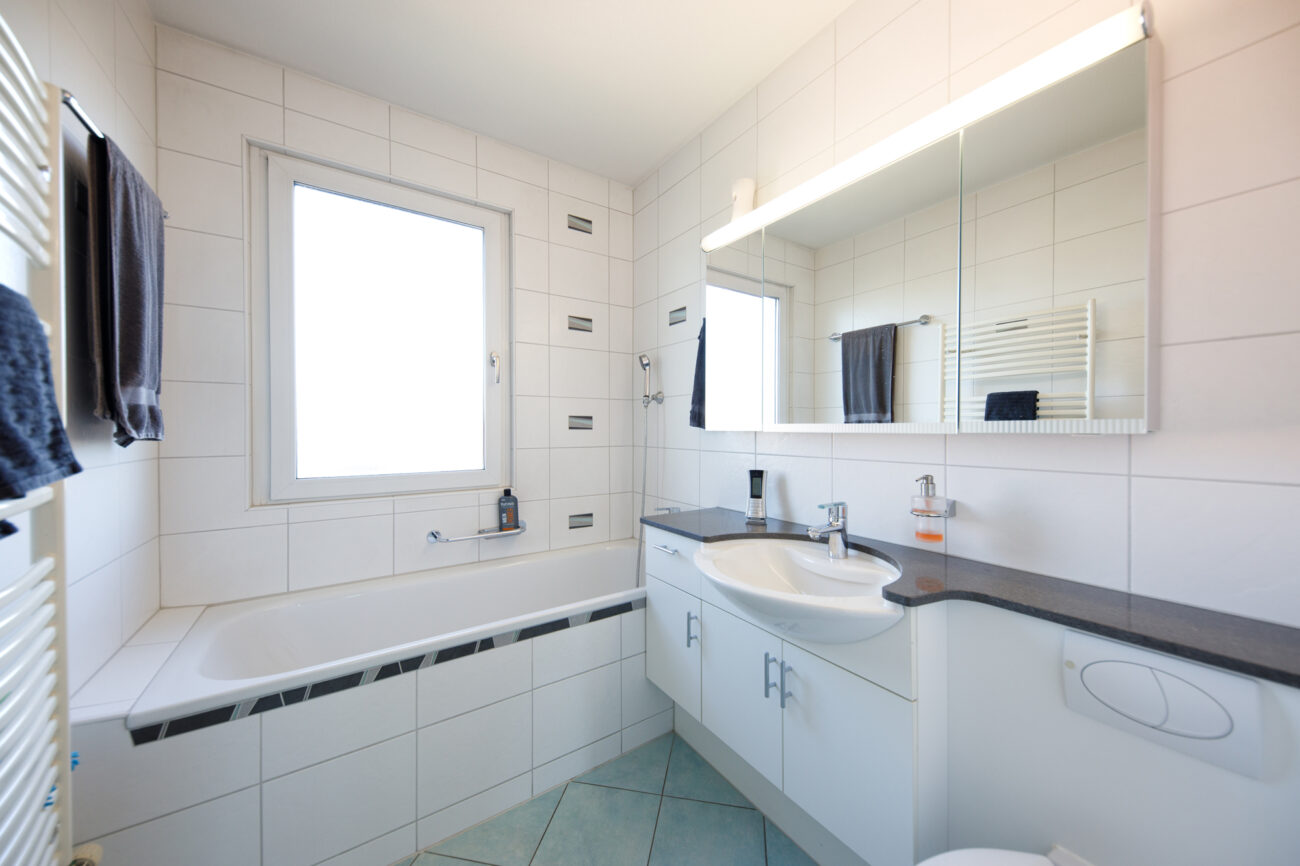 Helles Badezimmer mit Wanne und Waschtisch