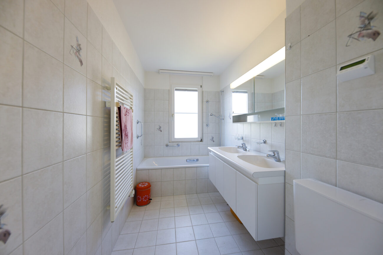 Helles Badezimmer mit Doppelwaschtisch und Badewanne