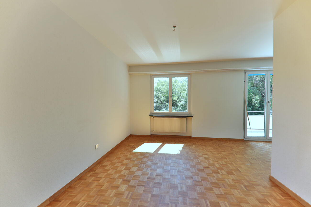Leerer Wohnraum mit Balkonzugang
