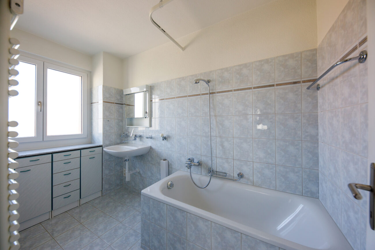 Helles Badezimmer mit Badewanne und Fenster