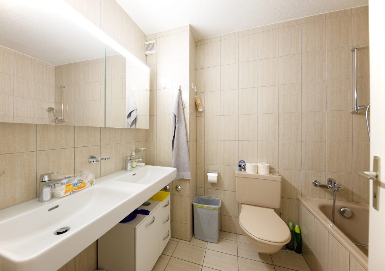 Beiges Badezimmer mit Doppelwaschtisch und Badewanne