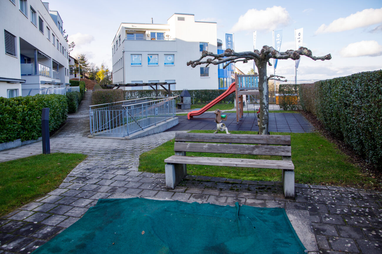 Außenbereich mit Spielplatz und Sitzbank