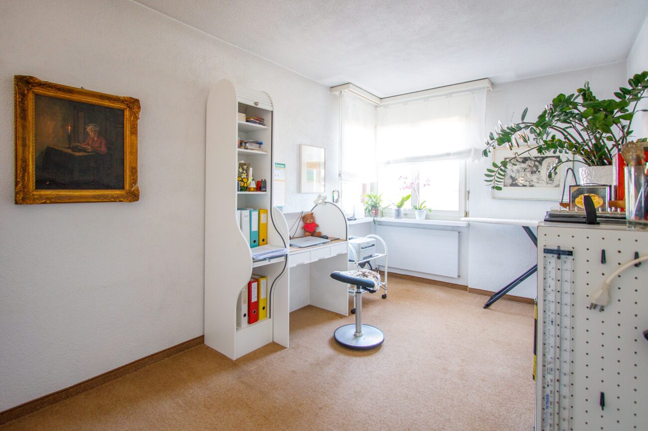 Helles Arbeitszimmer mit Fenster und Regalen