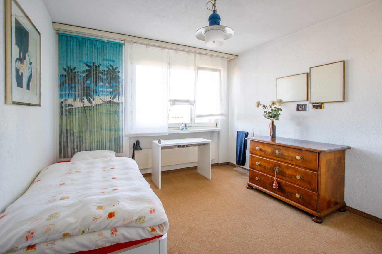 Helles Schlafzimmer mit Einzelbett und Schreibtisch