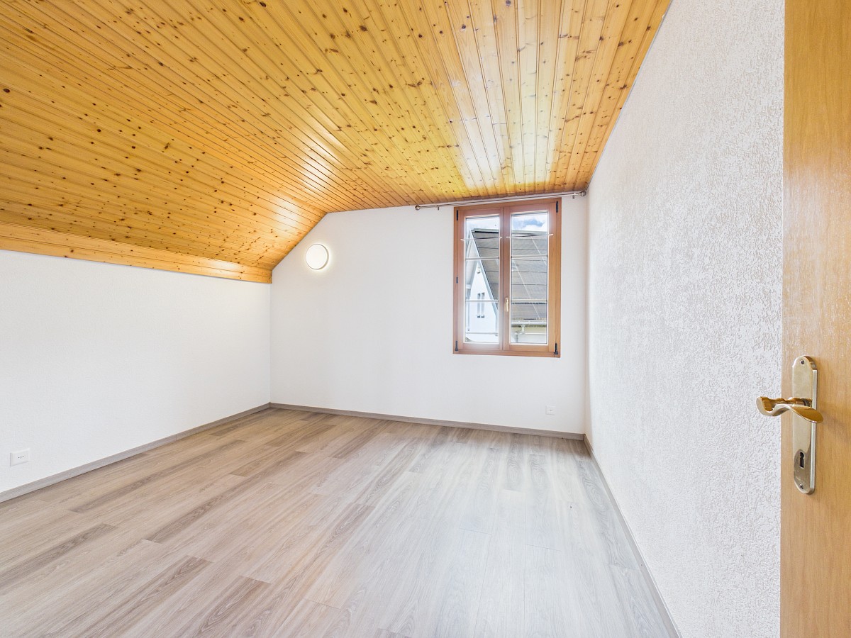 Helles Dachzimmer mit Holzdecke