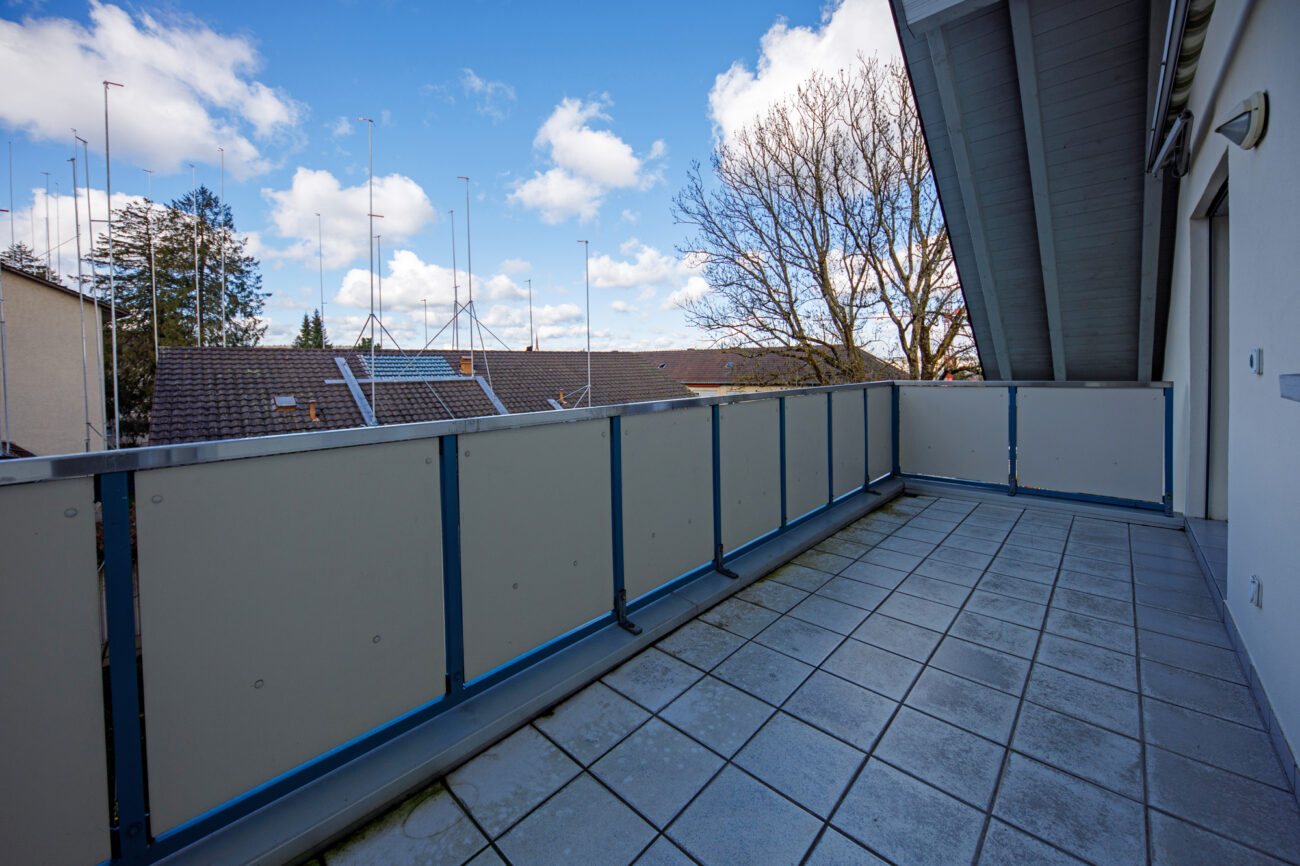 Balkon mit Blick auf Nachbarhäuser und Himmel