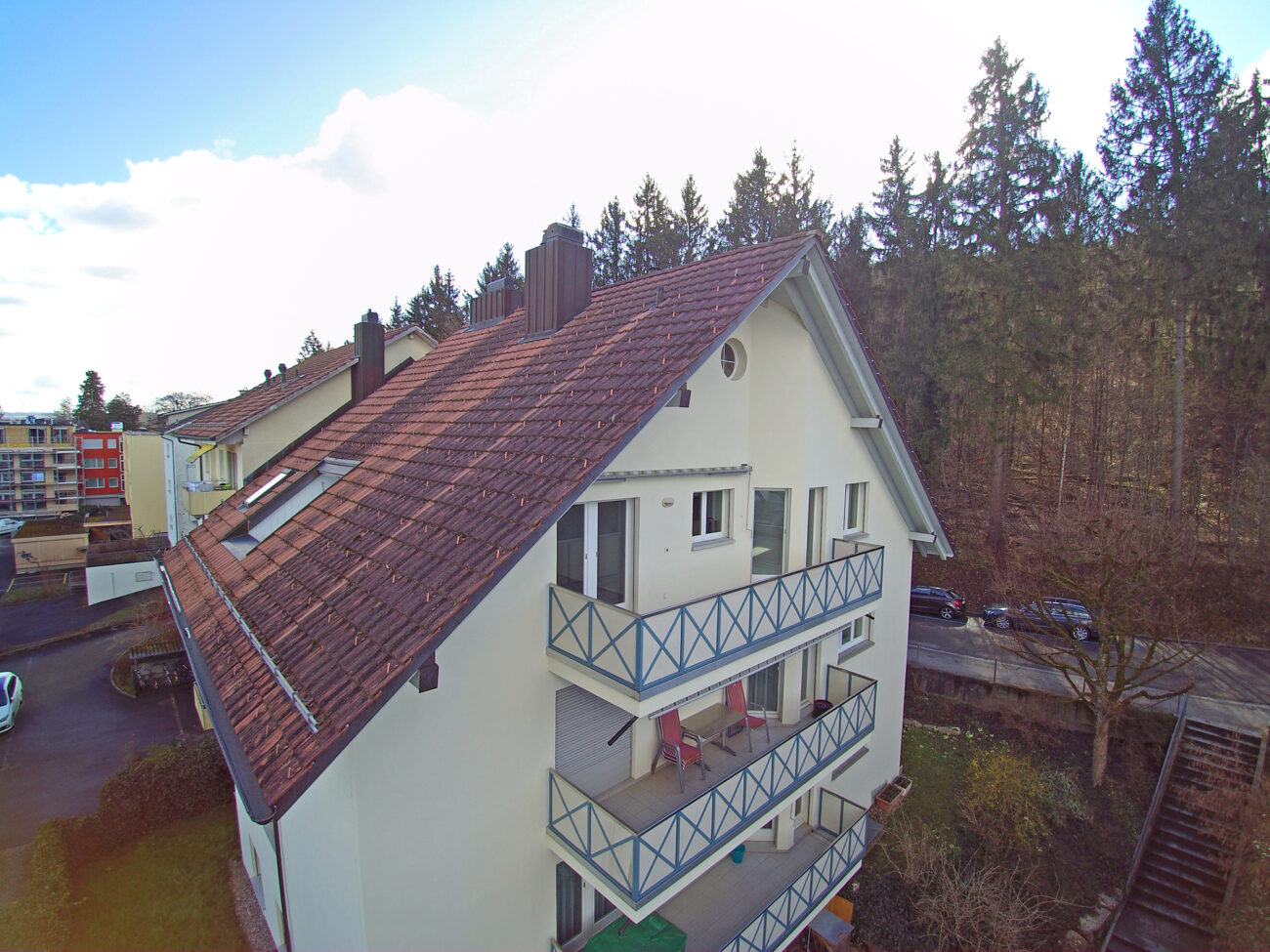 Mehrfamilienhaus mit steilem Satteldach und Balkonen