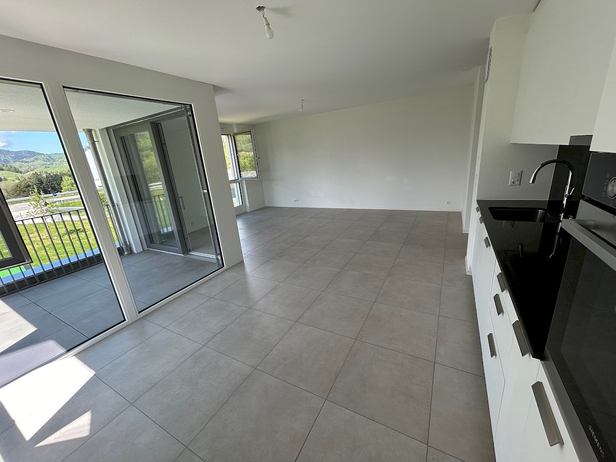 Offener Wohnbereich mit Balkon und Küche