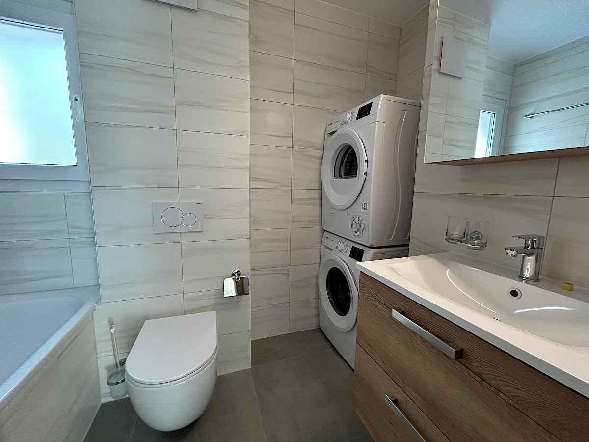 Modernes Badezimmer mit Waschtisch und Waschmaschine