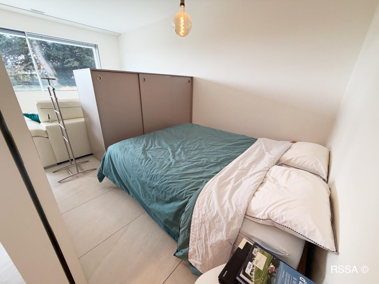 Kleines Schlafzimmer mit Fenster und Bett