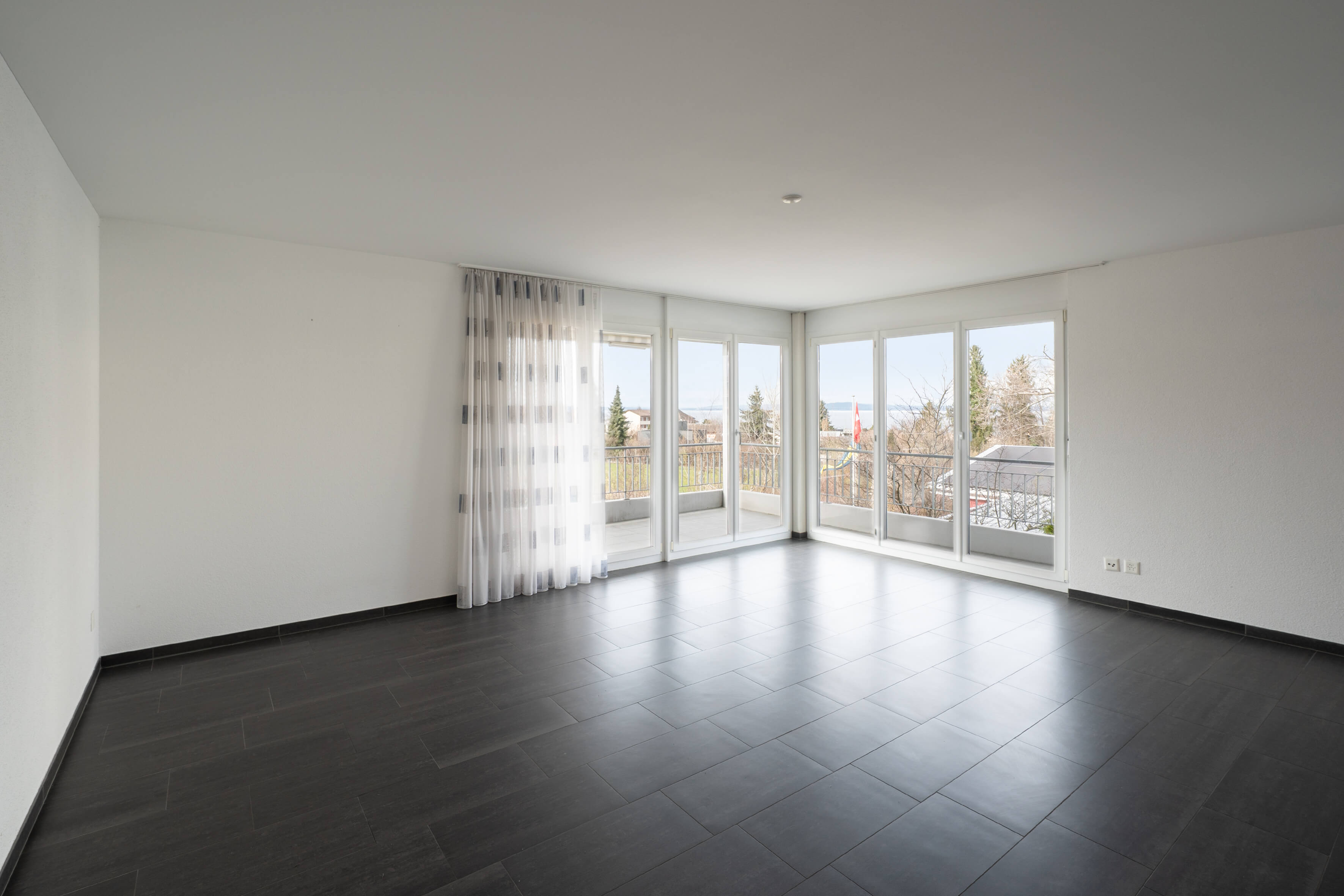 Leerer Wohnraum mit Balkon und Panoramafenstern