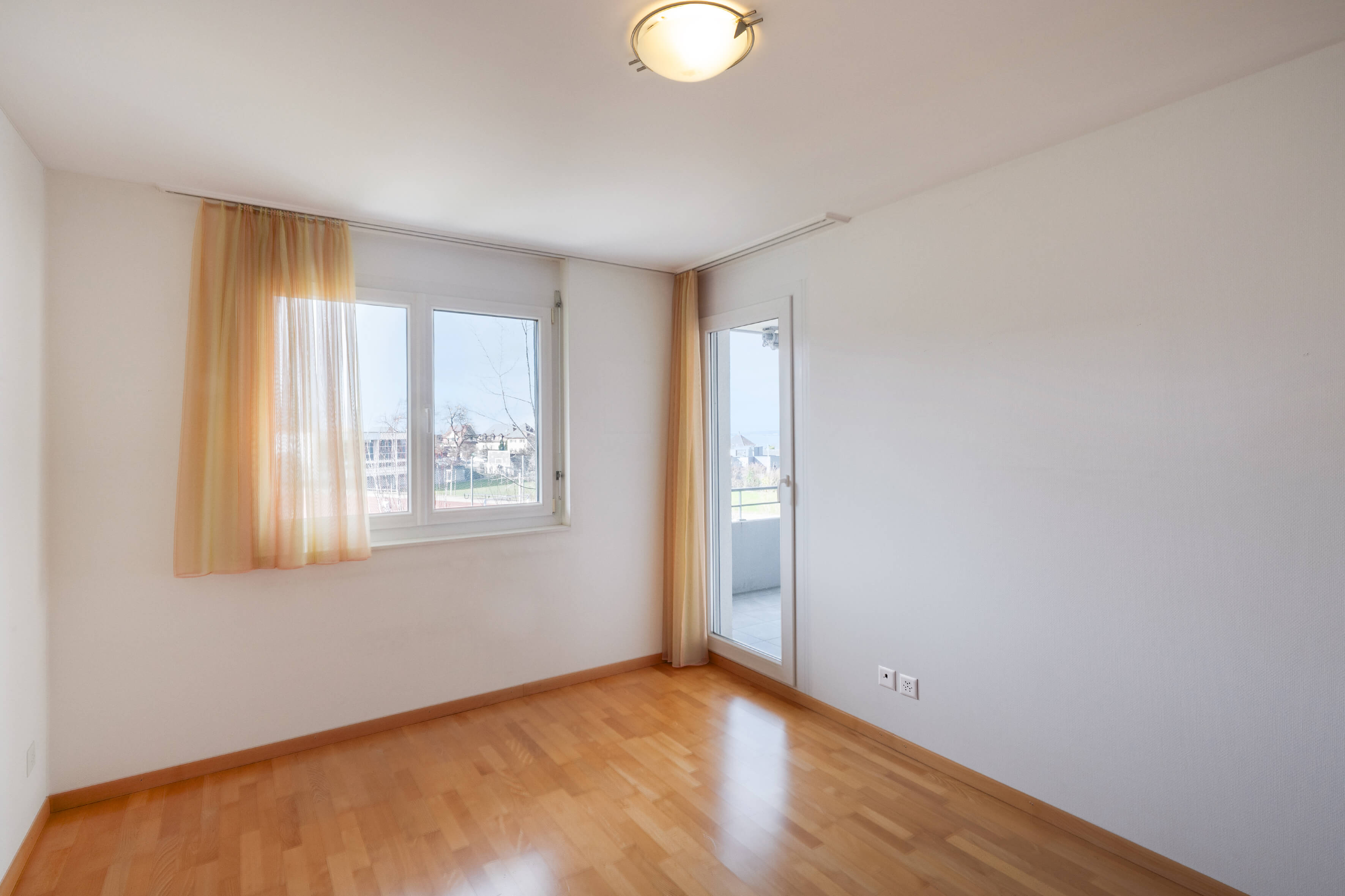 Helles, leeres Zimmer mit Balkonzugang