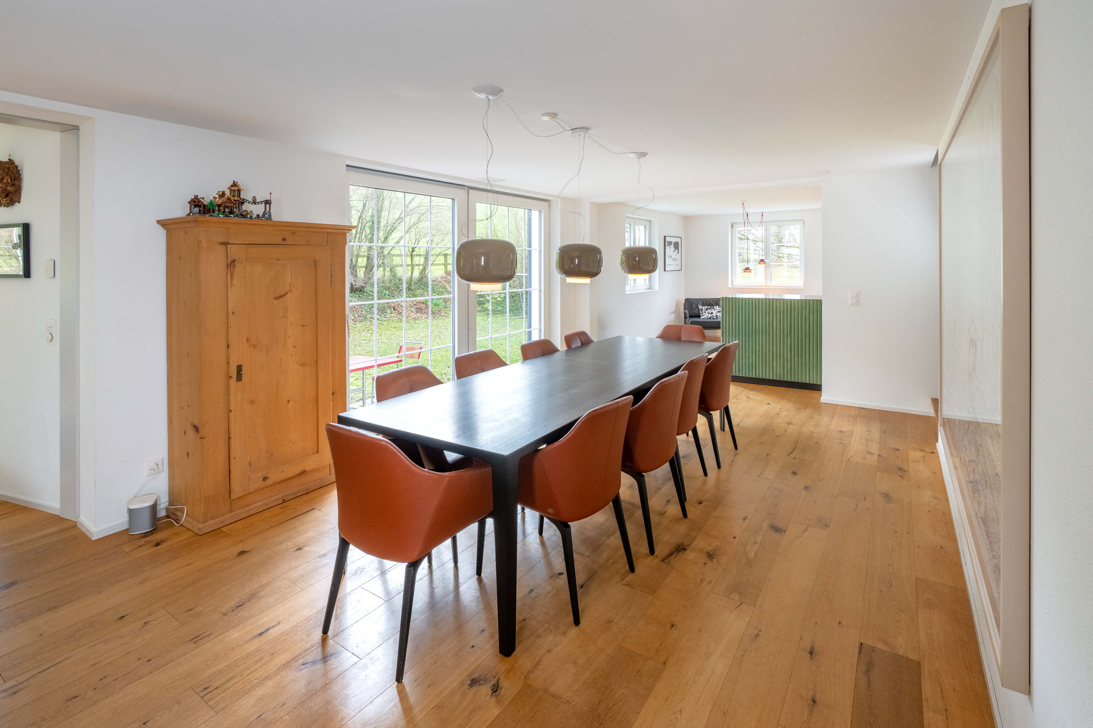 Esszimmer mit großem Holztisch und Gartenblick