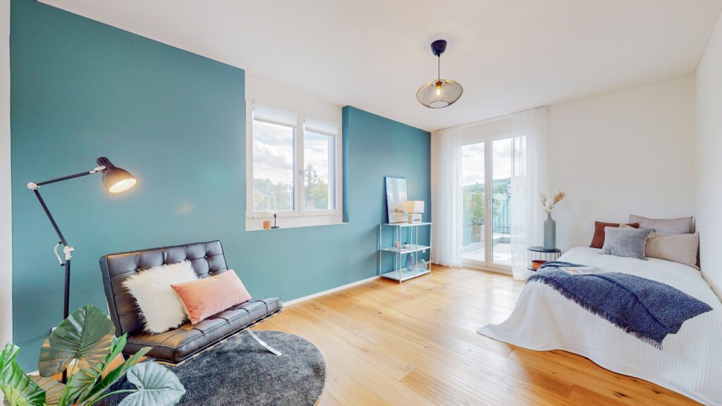 Helles Schlafzimmer mit Balkon und blaugrüner Akzentwand