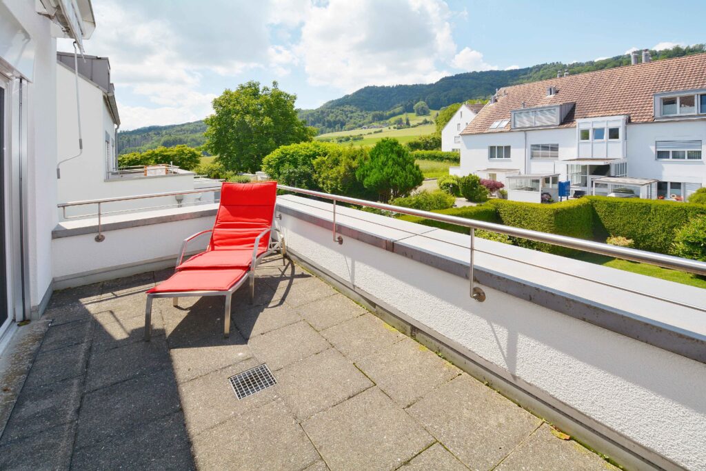 Balkon mit Sonnenliege und Bergblick