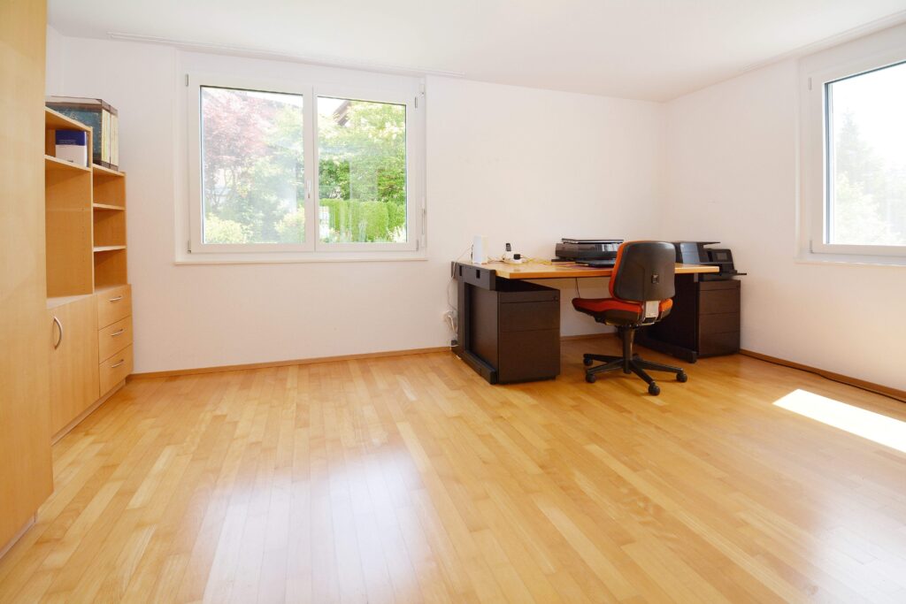 Heller Arbeitsraum mit Holzparkett und Schreibtisch