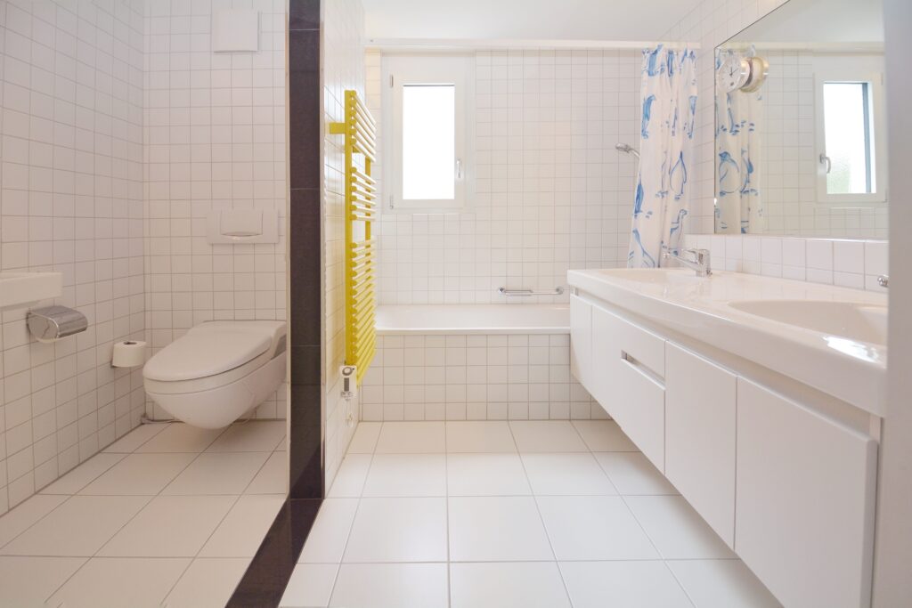 Helles Badezimmer mit Badewanne, Doppelwaschtisch und separatem WC-Bereich