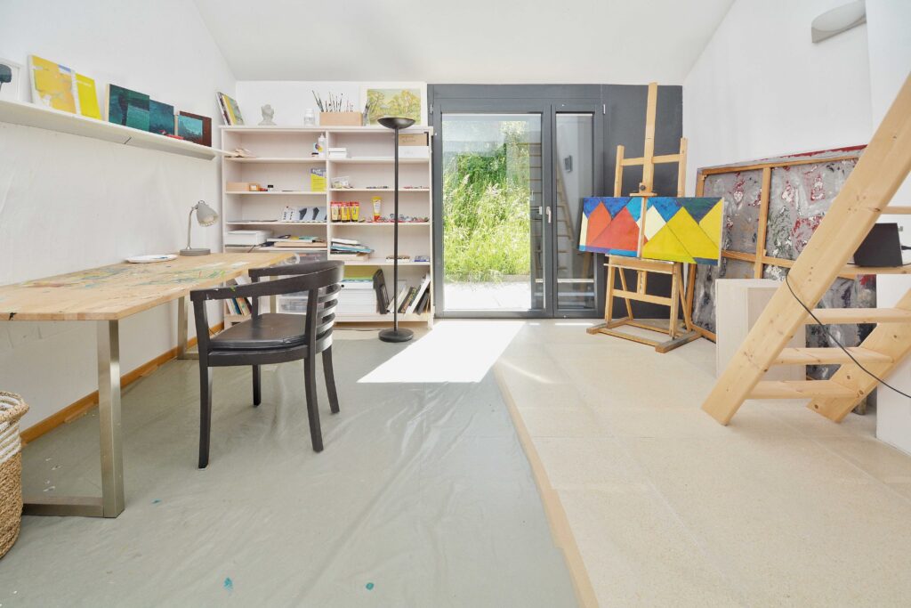 Atelierraum mit Arbeitstisch und Staffelei