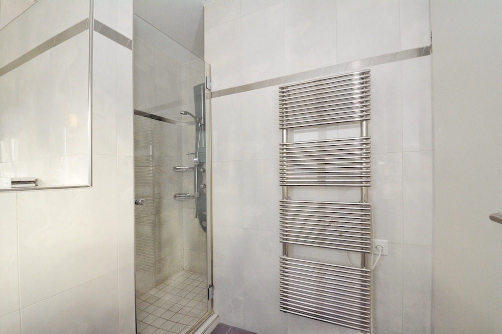 Modernes Badezimmer mit Dusche und Handtuchheizkörper