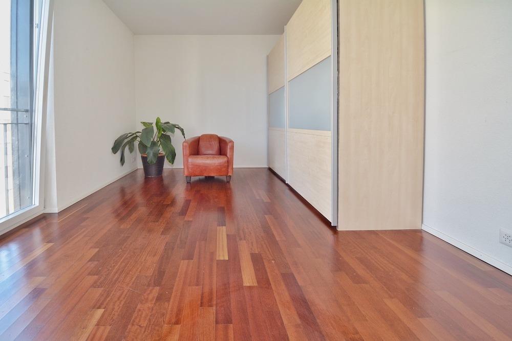 Heller Raum mit Parkett und Einbauschrank