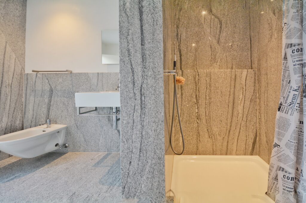 Modernes Badezimmer mit Naturstein und Badewanne