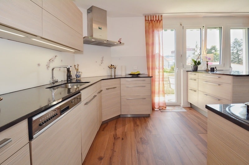 Helle moderne Küche mit Holzoptik und schwarzer Arbeitsplatte