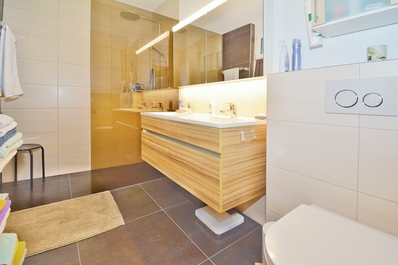 Modernes Badezimmer mit Holzwaschtisch und großer Spiegelfläche