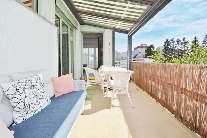 Überdachter Balkon mit Sitzgruppe