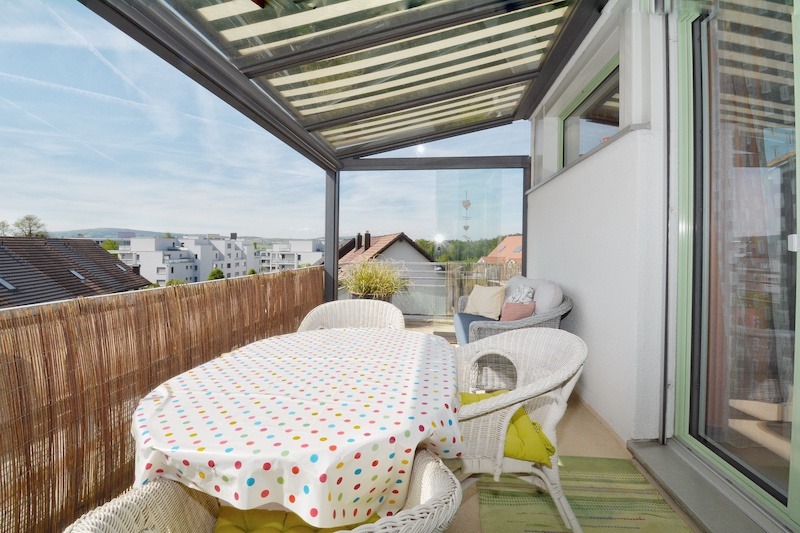 Überdachter Balkon mit Sitzgruppe