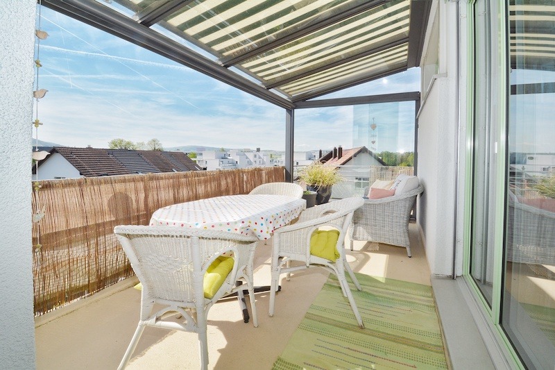 Überdachte Balkonterrasse mit Sitzgruppe