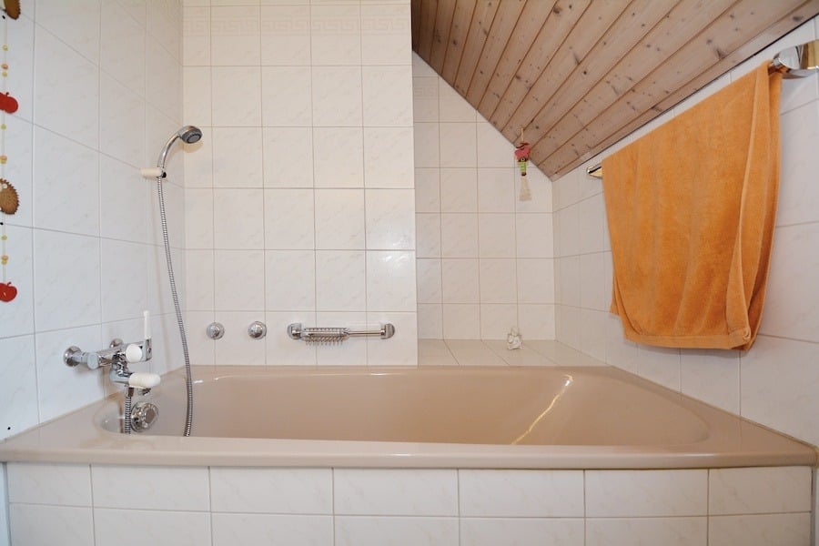 Badezimmer mit Badewanne unter Dachschräge
