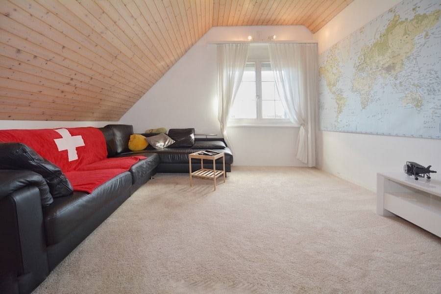 Gemütliches Dachzimmer mit Sofa und Karte