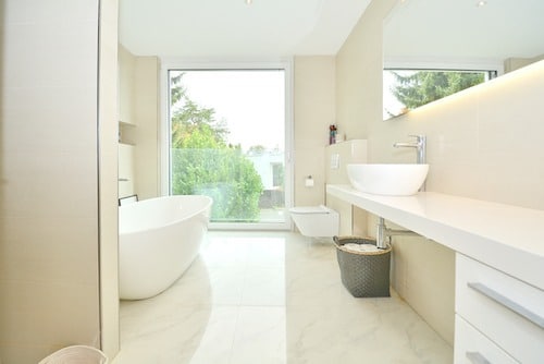 Modernes Badezimmer mit freistehender Wanne und großem Fenster